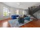 Bright living room with large windows, a stylish blue sofa, hardwood floors, and modern furnishings at 101 Morris St # D, Durham, NC 27701