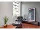 Contemporary sitting area with modern chair and footstool; large window provides natural light at 101 Morris St # D, Durham, NC 27701