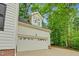 White two car garage with windows on top, surrounded by mature trees at 105 Parkmount Cir, Cary, NC 27519
