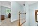 Upstairs hallway with wood railing leads to a bedroom with natural light at 105 Parkmount Cir, Cary, NC 27519