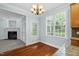 Bright eat-in kitchen with a chandelier, window, door and fireplace in the background at 105 Parkmount Cir, Cary, NC 27519
