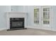 Bright living room featuring a fireplace with black marble and white mantle and french doors at 105 Parkmount Cir, Cary, NC 27519
