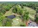 Scenic aerial view of the golf course with lush fairways, sand traps, and a tranquil pond at 106 Birkhaven Dr, Cary, NC 27518