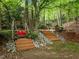 Multi-level backyard with a swing, wooden deck, and lush landscaping at 106 Birkhaven Dr, Cary, NC 27518