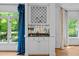 A wet bar featuring a mirrored backsplash, wine rack, and decorative curtains framing the adjacent windows at 106 Birkhaven Dr, Cary, NC 27518