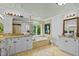 Luxury bathroom with double sink vanity, soaking tub under a window, and granite countertops at 106 Birkhaven Dr, Cary, NC 27518