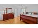 Cozy bedroom featuring hardwood floors, a dresser with a mirror, and natural light from a window at 106 Birkhaven Dr, Cary, NC 27518