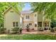 Rear exterior of the home featuring a patio, lush landscaping, and a serene backyard, blending indoor and outdoor living at 106 Birkhaven Dr, Cary, NC 27518
