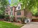 Spacious two-story brick home with driveway, garages, and lush greenery at 106 Birkhaven Dr, Cary, NC 27518