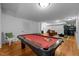 Game room featuring pool table with red felt, hardwood floors, and comfortable seating at 106 Birkhaven Dr, Cary, NC 27518