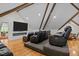 Attic home theater featuring tiered seating, exposed beams, and a large flat screen TV at 106 Birkhaven Dr, Cary, NC 27518