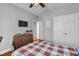 Comfortable bedroom with a plaid bedspread, ceiling fan, closet, and a dresser with TV above at 106 Jj Dr, Benson, NC 27504
