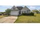 Charming gray home with manicured lawn, complemented by a two-car garage and mature landscaping at 106 Jj Dr, Benson, NC 27504