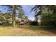 Spacious backyard featuring a well-maintained lawn and patio area under mature trees at 109 Edgewood Dr, Louisburg, NC 27549