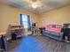 A cozy bedroom featuring wood flooring, a ceiling fan, a work desk, and comfortable seating at 109 Edgewood Dr, Louisburg, NC 27549