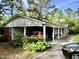 Brick home featuring a convenient carport, complemented by lush landscaping at 109 Edgewood Dr, Louisburg, NC 27549
