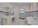 Bathroom featuring a vanity with a built-in makeup counter and large mirror, with a blue tile wall and patterned floors at 1105 Hargrove St, Henderson, NC 27536