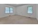 Bedroom with neutral carpet, baseboard trim, and two windows that provide lots of natural light at 1105 Hargrove St, Henderson, NC 27536