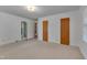 Bedroom with neutral carpet and three closet doors; Primary bath is also visible at 1105 Hargrove St, Henderson, NC 27536