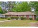Brick home featuring mature landscaping and a well-manicured lawn at 1105 Hargrove St, Henderson, NC 27536