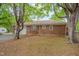 Back of home featuring a brick exterior, windows, and a well-maintained yard with mature trees at 1105 Hargrove St, Henderson, NC 27536