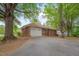 Ranch home showcasing a brick exterior, two car garage, and mature trees in a well-maintained yard at 1105 Hargrove St, Henderson, NC 27536