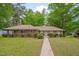 Charming brick home with a well-maintained lawn and mature trees providing shade at 1105 Hargrove St, Henderson, NC 27536
