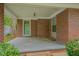 Brick home front porch featuring a green door and trim, providing a shaded entry and curb appeal at 1105 Hargrove St, Henderson, NC 27536