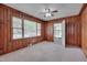 Living room features wood paneling, a ceiling fan, and lots of natural light at 1105 Hargrove St, Henderson, NC 27536