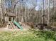 Backyard featuring wooden playset with slide and swingset, plus stone firepit area with Adirondack chairs at 1108 Kalworth Rd, Wake Forest, NC 27587