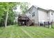 An expansive backyard features a deck, green grass, and privacy provided by mature trees at 1108 Kalworth Rd, Wake Forest, NC 27587