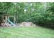 A backyard showcasing a play area, fire pit, and lush greenery creating an inviting outdoor space at 1108 Kalworth Rd, Wake Forest, NC 27587