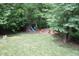 Aerial backyard view showcasing a play area, fire pit, and lush greenery at 1108 Kalworth Rd, Wake Forest, NC 27587