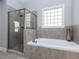 Bright bathroom showcasing a glass shower, soaking tub, and large tile-framed window at 1108 Kalworth Rd, Wake Forest, NC 27587