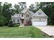 Charming two-story home featuring stone accents, a two-car garage, and a well-manicured lawn at 1108 Kalworth Rd, Wake Forest, NC 27587
