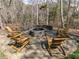 Relaxing outdoor space with stone firepit, surrounded by seating area and wooded backdrop at 1108 Kalworth Rd, Wake Forest, NC 27587