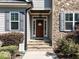 Inviting front entrance with a stone facade, a stylish wooden door, and well manicured shrubs at 1108 Kalworth Rd, Wake Forest, NC 27587