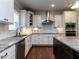 Modern kitchen with white cabinetry, granite countertops, stainless steel appliances, and hardwood floors at 1108 Kalworth Rd, Wake Forest, NC 27587