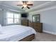 Light-filled main bedroom features a tray ceiling, ceiling fan, TV, and a window at 1108 Kalworth Rd, Wake Forest, NC 27587