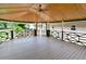 Spacious screened deck with wooden flooring, decorative railings, and a ceiling fan creates a charming outdoor living space at 113 Gulf Drive Dr, Dunn, NC 28334