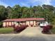 Inviting one-story home featuring a red metal roof and beautiful rose bushes at 113 Gulf Drive Dr, Dunn, NC 28334