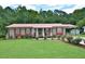 Well-maintained home with a manicured lawn, red roof and shutters, and mature landscaping at 113 Gulf Drive Dr, Dunn, NC 28334