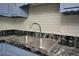 Close-up of a kitchen sink with modern fixtures and elegant black countertops at 113 Gulf Drive Dr, Dunn, NC 28334