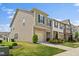 Townhome featuring a stone facade, attached garage, and manicured landscaping at 1141 Amber Shadow Dr # 101, Durham, NC 27703