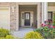 Inviting front porch with stone accents, a bench, and colorful flowers at 1141 Amber Shadow Dr # 101, Durham, NC 27703
