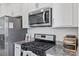 Close-up of the kitchen with stainless steel oven and microwave, and granite countertops at 1141 Amber Shadow Dr # 101, Durham, NC 27703