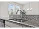 Kitchen sink beneath windows providing lots of natural light atop granite countertops at 1141 Amber Shadow Dr # 101, Durham, NC 27703