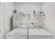 Bright laundry room featuring side-by-side washer and dryer with wire rack shelving for storage at 1141 Amber Shadow Dr # 101, Durham, NC 27703
