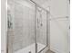Glass-enclosed shower featuring square tile, a shower head, and built in shelves at 1141 Amber Shadow Dr # 101, Durham, NC 27703