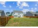 Large backyard featuring grass, a wooden fence, and a partial view of the house at 115 Bourne Dr, Franklinton, NC 27525